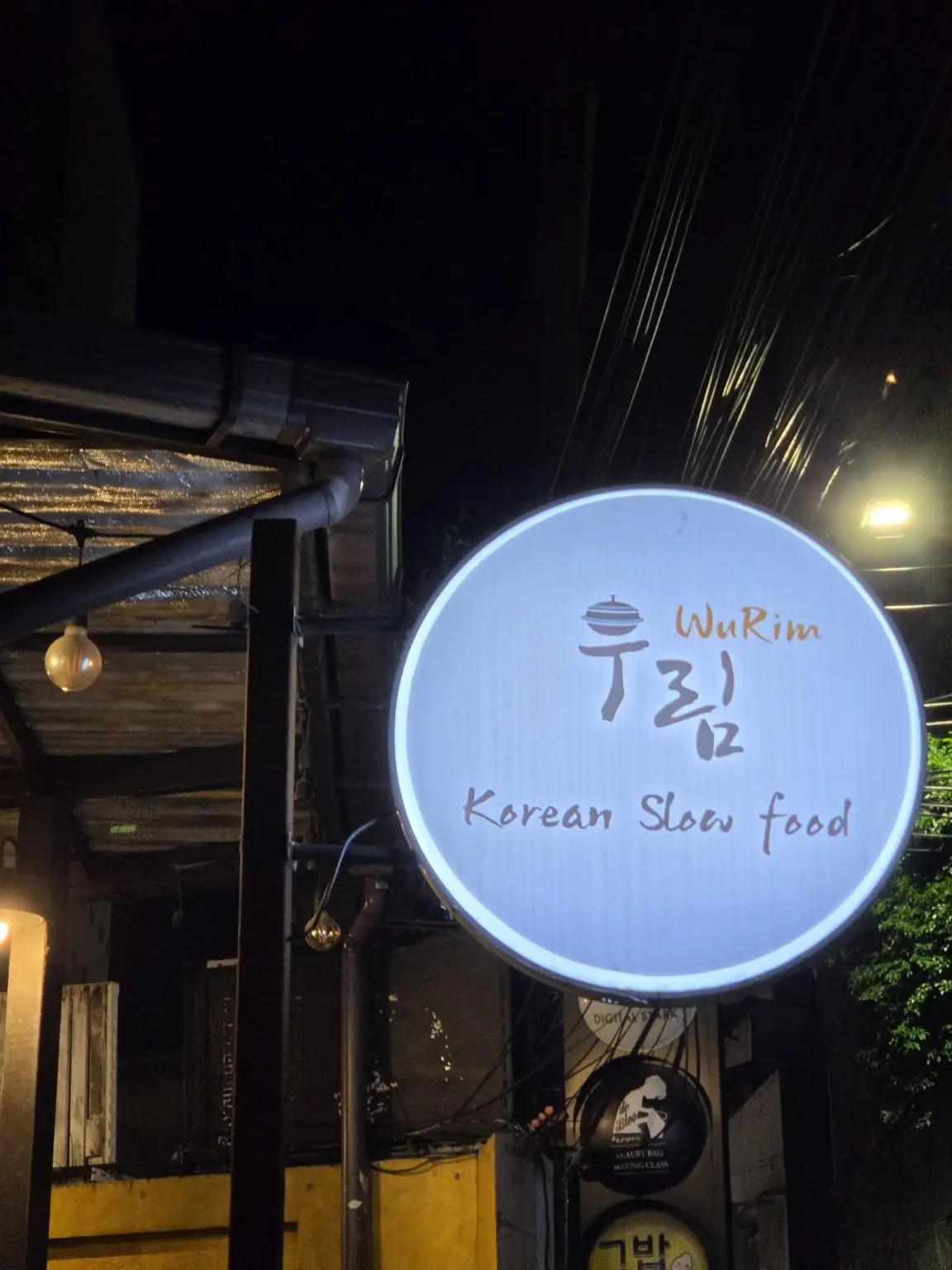 The WuRim sign lit up at night — WuRim Korean Slow Food (우림), Bangkok