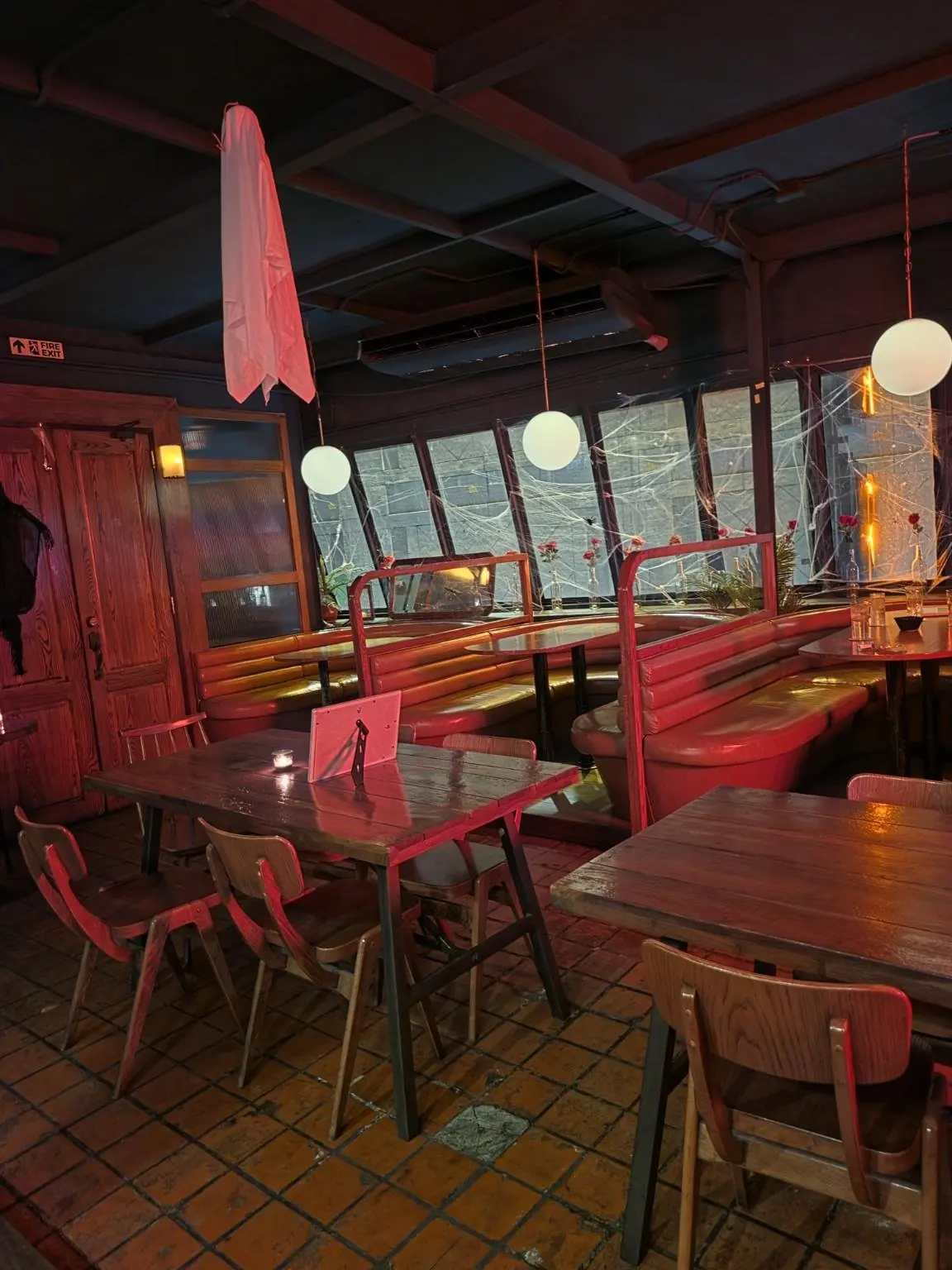 Tables and sofa seats under red lights. — Mutual Bar, Sukhumvit 24 (5th floor), Phrom Phong, Bangkok
