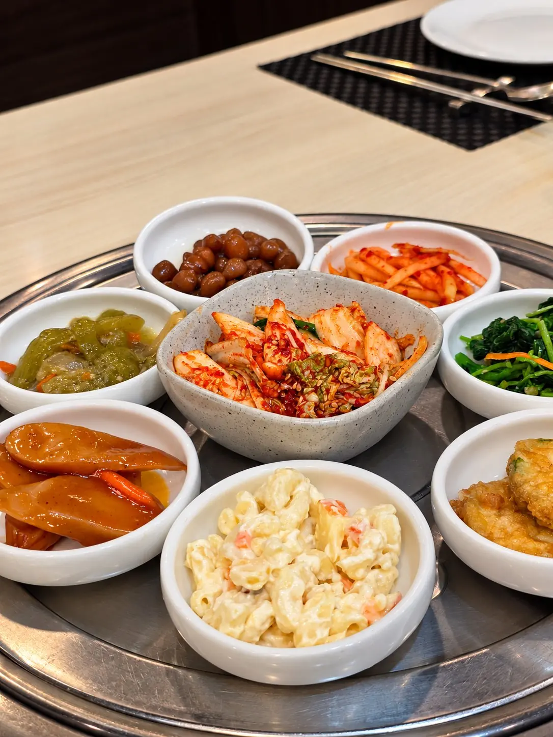 A table set with an array of side dishes. — Dae Jang Geum, Prasanmit Plaza, Sukhumvit Soi 23, Asok, Bangkok