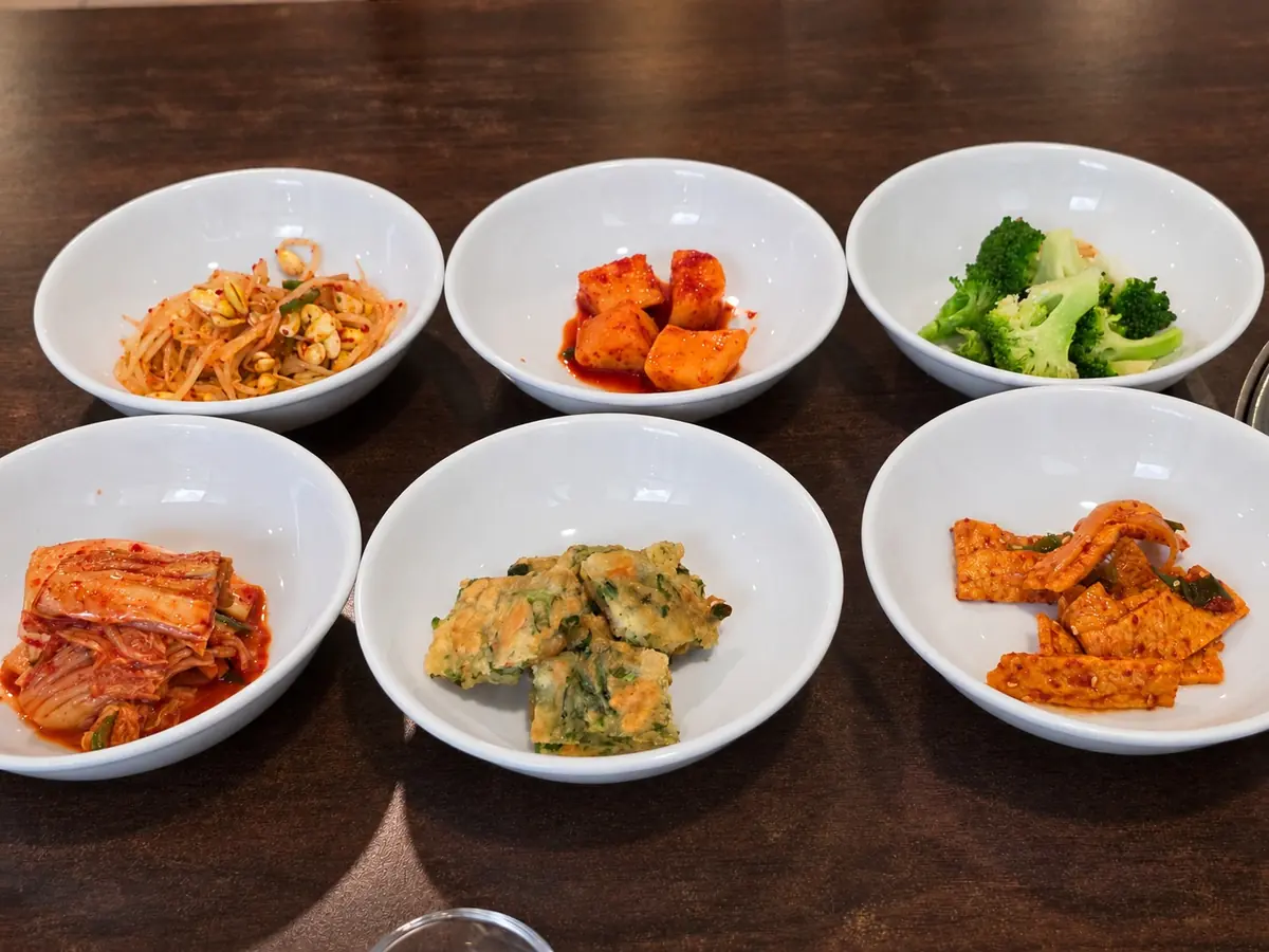 包括泡菜、蘿蔔塊泡菜、炒魚板和煎餅在內的六樣小菜。🥢 — Manchan Korean Restaurant (2nd floor), Phrom Phong, Bangkok