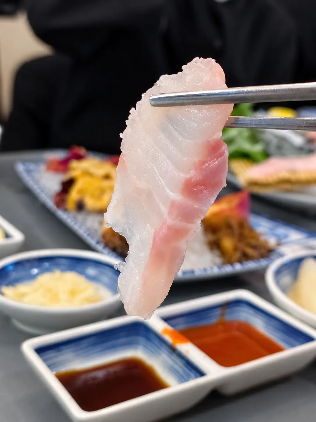 箸でつまんだ刺身の一切れ 🥢 — ヘファロ