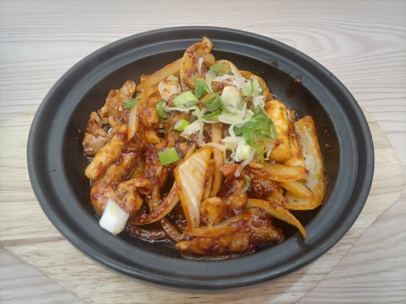 Chicken and vegetables stir-fried on a hot pan in chilli sauce