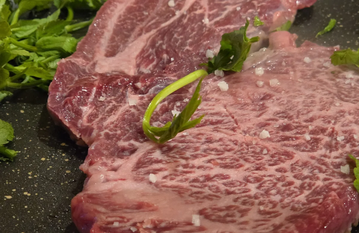 Marbled Hanwoo beef with flaky salt and minari, ready for the grill at Haehwaok