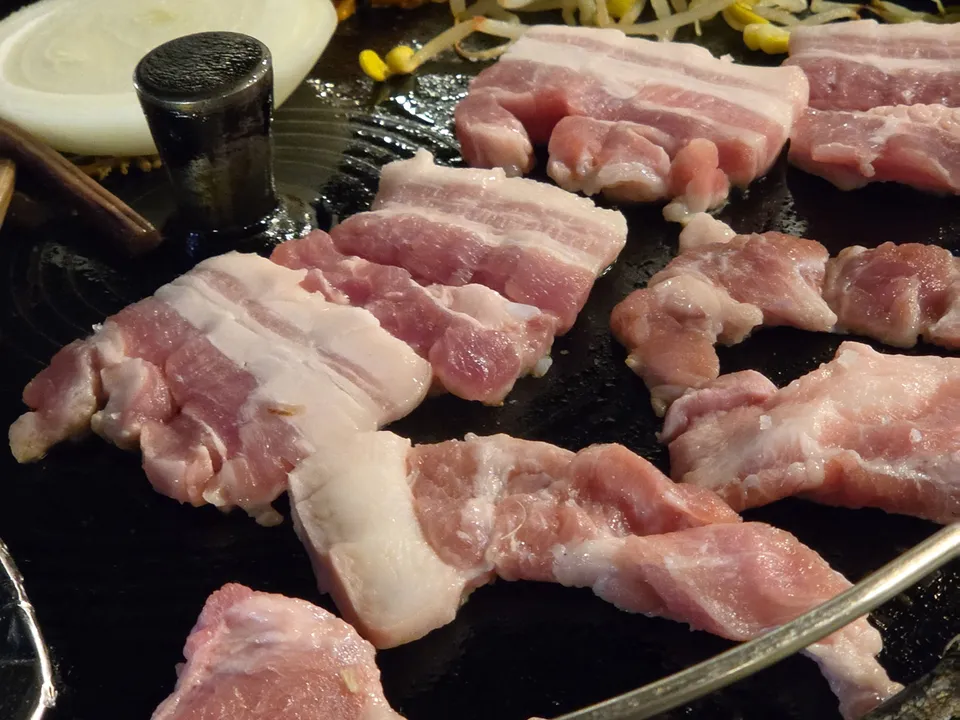 Thick pork belly on a cast-iron lid grill at Nonhyeondon, near Nonhyeon Station, Seoul